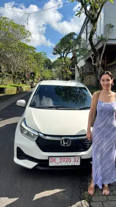 A customer with our white Honda Brio on a villa driveway
